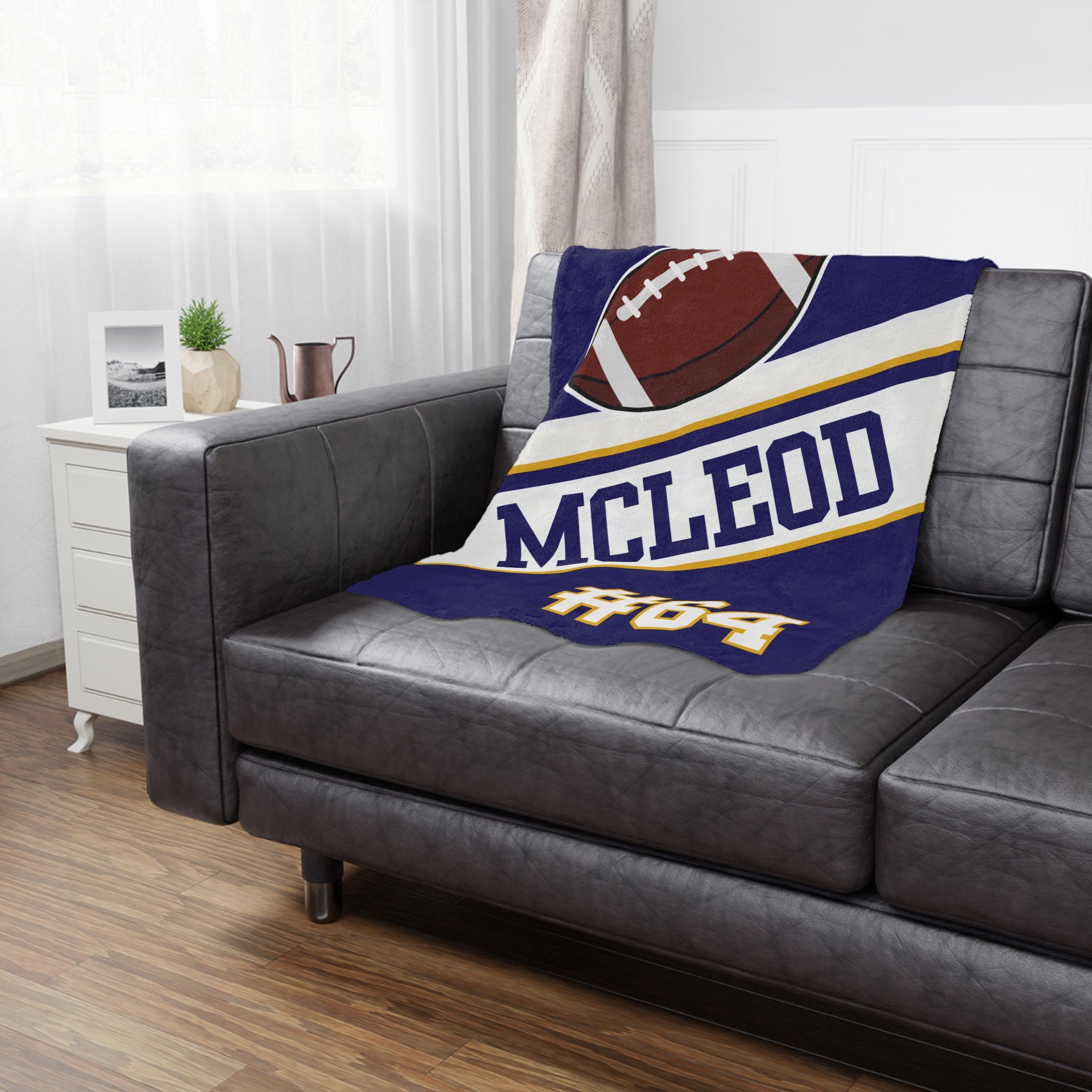 Blanket with 'McLeod' and football design on a gray sofa