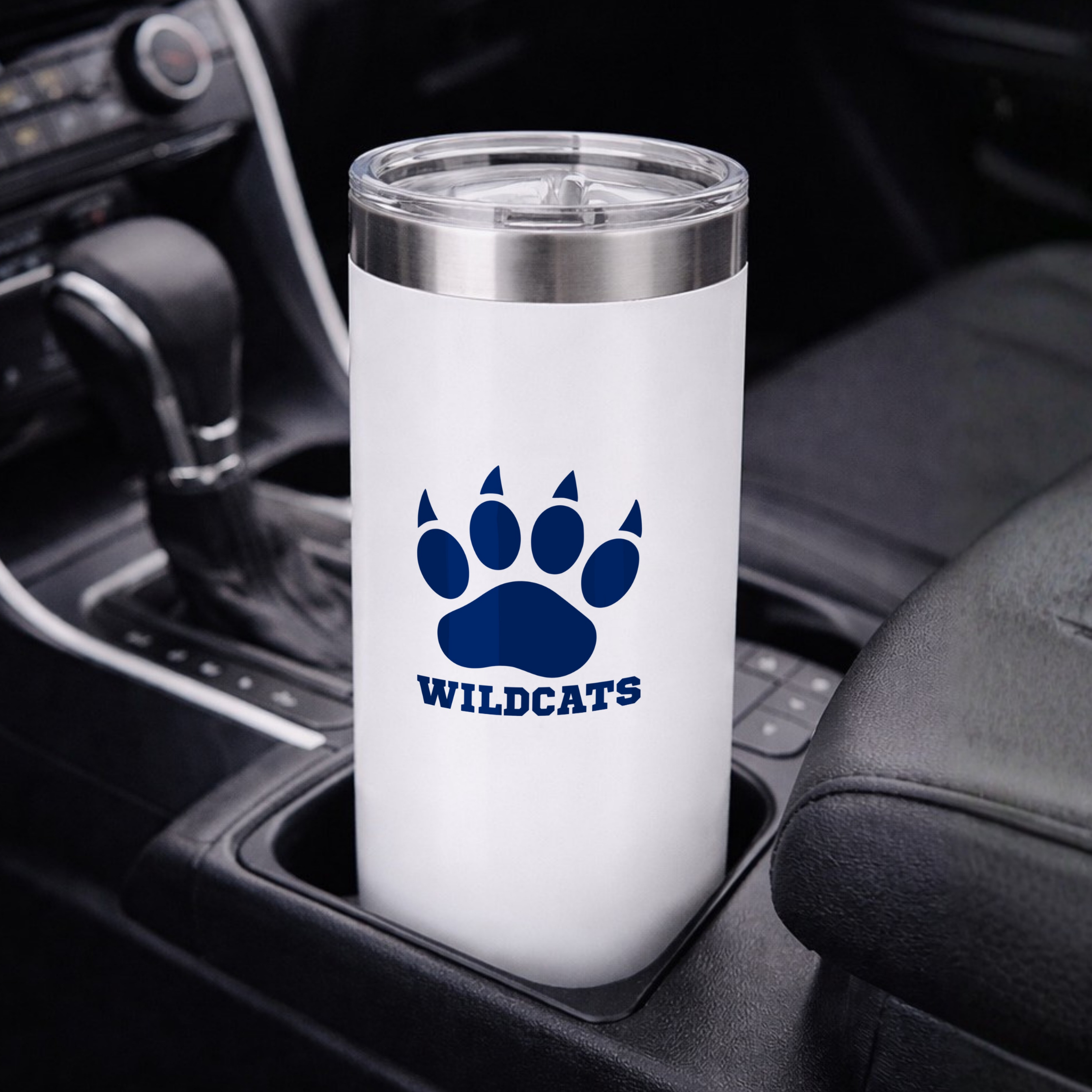 White tumbler with blue paw print and 'Wildcats' text in a car cup holder.