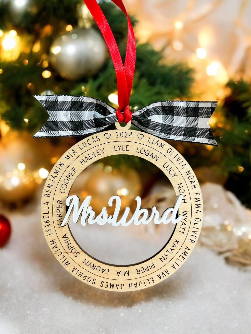 Wooden ornament with 'Mrs Ward' text on a Christmas tree background