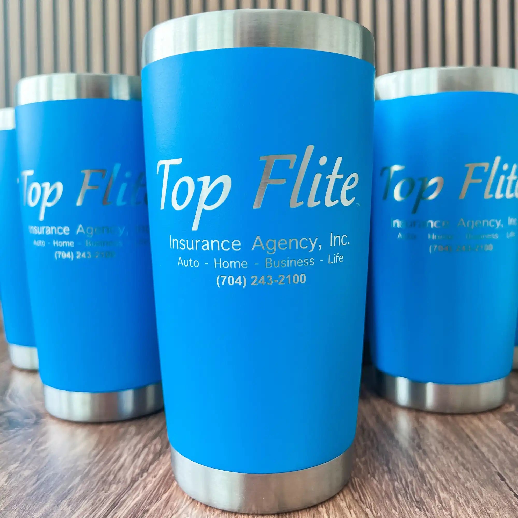Blue stainless steel tumbler with ’top flite insurance agency, inc.’ branding.