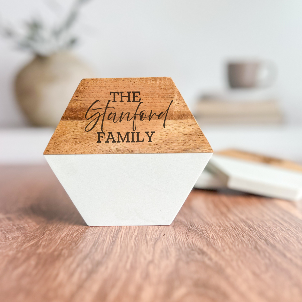 Wooden and white geometric object with 'The Stanford Family' engraving on a wooden surface.
