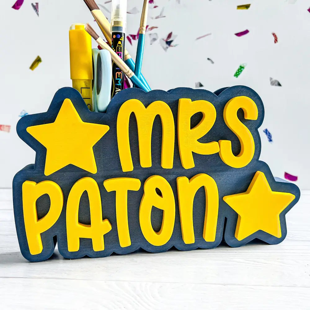 Personalized pencil holder with 'MRS PATON' text and stars on a white background