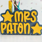 Pencil holder with 'MRS PATON' text and stars on a white background