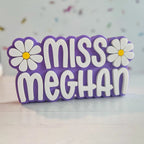 Personalized nameplate with flowers on a wooden surface